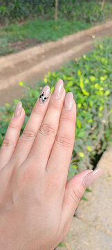 Manicured hand and nails outside in the park