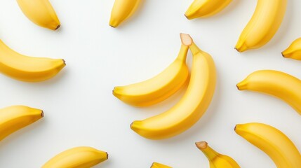 Pattern of bright yellow ripe bananas scattered on white surface