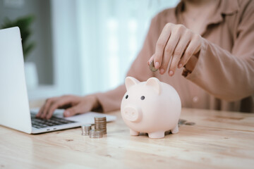 Woman putting money in piggy bank, money saving concept