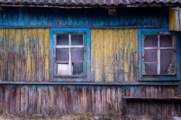 Abandoned Wooden Village House with Blue and Yellow Facade