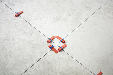 Close-up of ceramic tile installation with tile clips and spacers for grouting