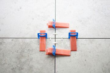 Close-up of ceramic tile installation with tile clips and spacers for grouting