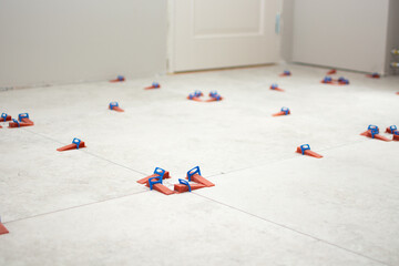 Close-up of ceramic tile installation with tile clips and spacers for grouting