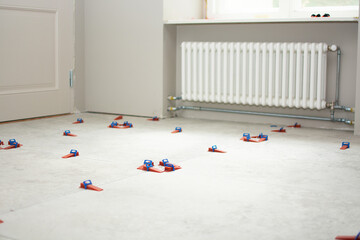 Close-up of ceramic tile installation with tile clips and spacers for grouting