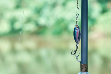 Close-up of a fishing rod. Fishing on the shore of a lake, river. Spinning rods for sport fishing. There is space for text