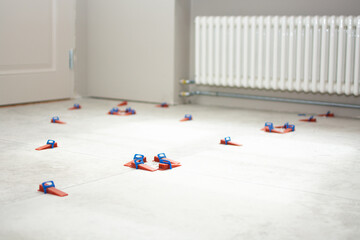 Close-up of ceramic tile installation with tile clips and spacers for grouting