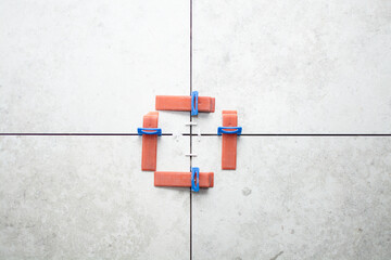 Close-up of ceramic tile installation with tile clips and spacers for grouting