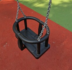 Vista de cerca de un asiento de seguridad de un columpio infantil en un parque