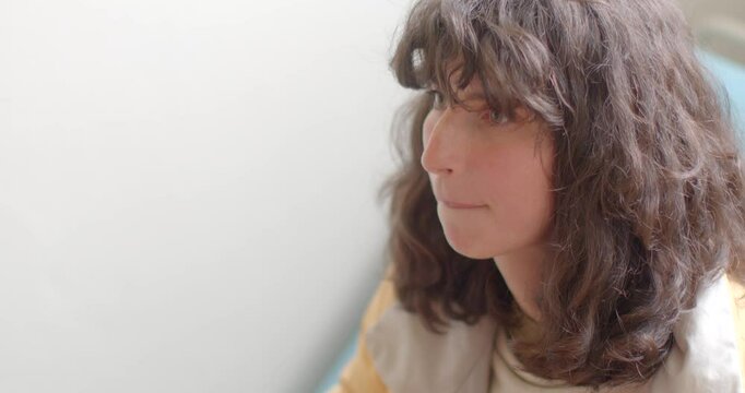 A person who has curly hair is animatedly expressing gestures during an engaging indoor conversation, showcasing the true essence of effective communication and human interaction