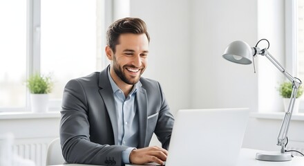 A joyful businessman radiates satisfaction while working in an office setting, bathed in soft, natural light.