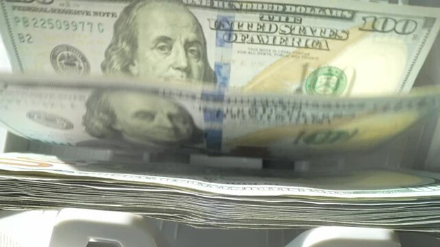 Close up cash counting machine counting money. Banknotes of 100 dollar bills. Money count machine, investment banking, cash transaction concept. Finance, currency and crisis recession.