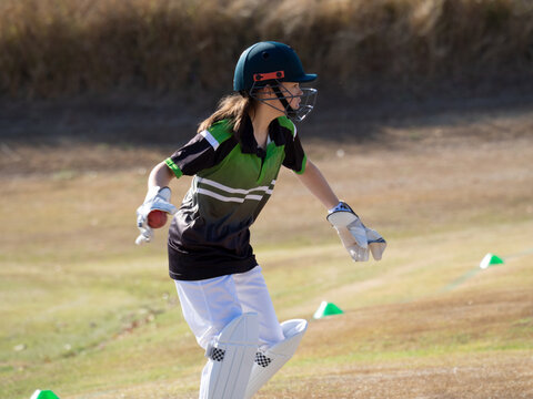 Women's cricket female wicket keeper catching the ball on the field