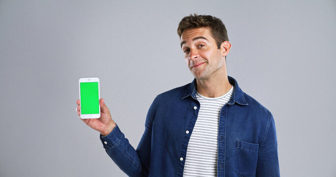 Man, portrait and phone with green screen for marketing new app, UI or UX on white background. Male person, model or user with mobile smartphone display or chromakey for advertising on mockup space