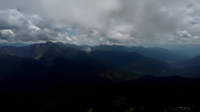 Aerial Cloudscape Over Mountain Valley with Dramatic Light and Shadow Play
