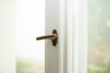 Close-up of an old window with a bronze handle for opening