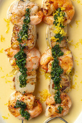 Portion of gourmet grilled shrimp skewers with sauce