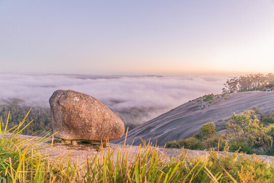 A misty morning sunrise on a granite monolith