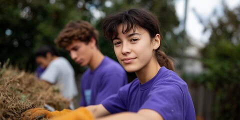Young caucasian female volunteer in purple shirt participating in outdoor community service