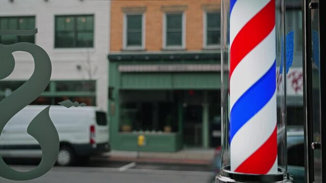 A view of a spinning barbershop pole on the main street of a small New England town on an overcast day.  	