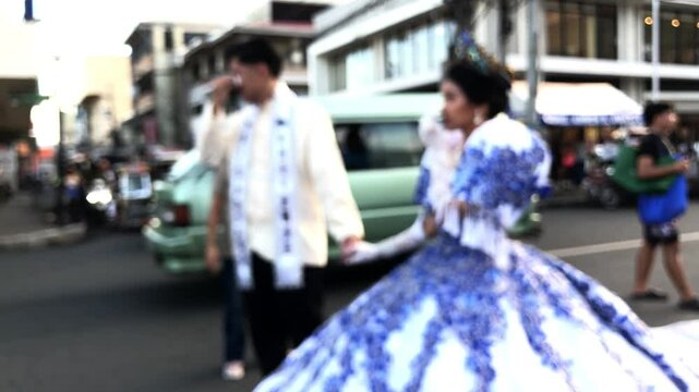 Defocused video footage of Mayflower pageantry tradition, young women dressed in traditional Filipino gowns parade the streets in honor of Helena, also known as Reyna Elena.