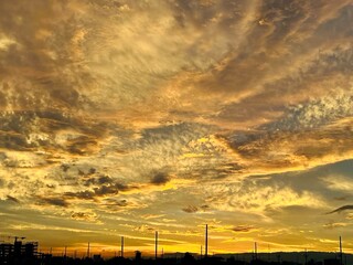 Obraz premium Dramatic Sunset Sky with Golden Clouds over Urban Horizon