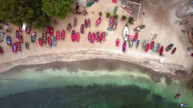 Aerial drone footage of Tarrafal Beach, Cape Verde, featuring crystal-clear turquoise waters, white sandy shore, and lush greenery along the peaceful coastline under a bright sunny sky