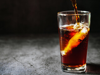 Pouring of Cola and Ice, Cola soft drink with ice cubes, soda fizzy drink in Cold glass