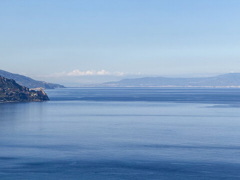 Waves gently lap at the shoreline of the Mediterranean, with serene blue waters meeting the horizon on a clear day. Coastal hills rise in the background, completing the tranquil landscape - Powered by Adobe