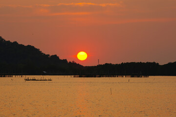 sunset with silhouette mountain over the sea