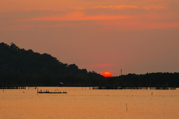 sunset with silhouette mountain over the sea