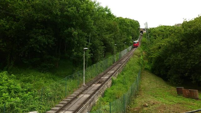 Bilbao Spain 04 06 2025 A red funicular climbs the hillside in Bilbao, offering scenic views of the city below. A charming and historic mode of transport in the Basque Country.