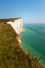 Tourists on the edge of Beachy Head cliff on the English Channel coast, East Sussex, UK