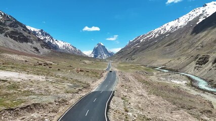 Aerial drone shot capturing the winding road leading up to Gombok Ranjan mountain. - Powered by Adobe