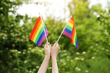 Teenager Holds Two Rainbow Flag LGBT in his Hands. Pride Month. Lesbian Gay Bisexual Transgender. Love, human rights, tolerance