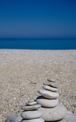 Coastal still life with balanced pebbles and ocean horizon.