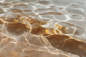 abstract reflections in water showcasing shadowy patterns created by beach elements