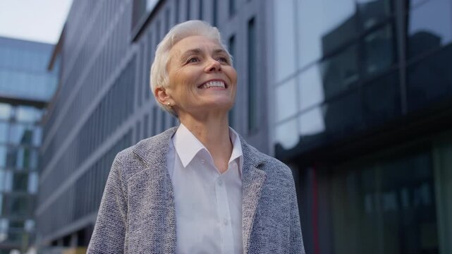 Smiling senior woman walking to work in city