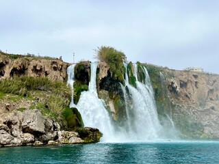 Duden Waterfalls in Antalya, Turkey, cascading into the turquoise blue waters of the Mediterranean Sea. Travel, summer vacation, Mediterranean coast, nature, scenic spot, Turkish Riviera. 