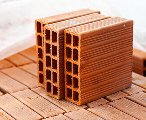 Close up of hollow bricks resting on wooden pallet during building construction