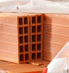 Close up of hollow clay bricks showing square holes, creating a geometric pattern