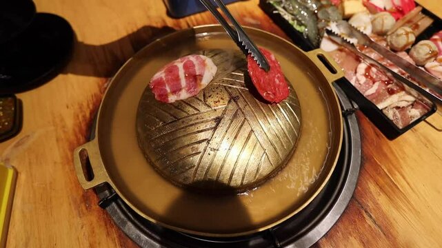 Top view of the traditional asian grill or hot pot in Thail restaurant cooking seafood and meat