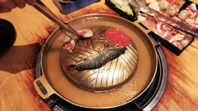Top view of the traditional asian grill or hot pot in Thail restaurant cooking seafood and meat