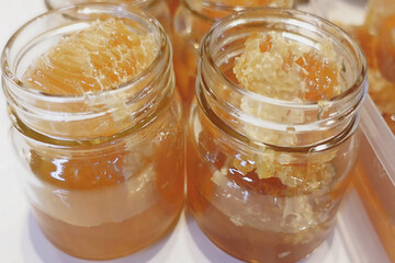 Close-up view of several glass jars filled with honeycomb