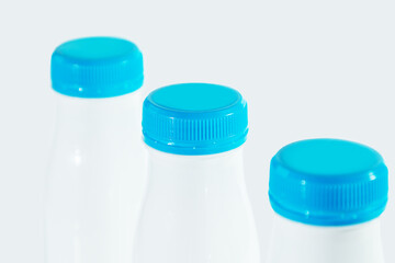 Three white plastic bottles from dairy products.