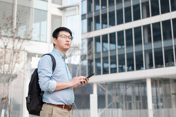 Fototapeta premium asian businessman using smart phone out of office building