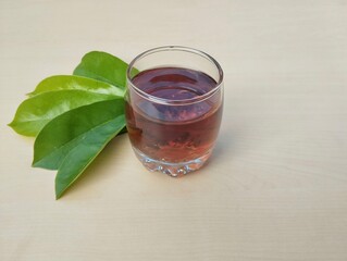 Soursop leaf boiled water in glass on wooden table, high angle view. Healthy drink lifestyle	