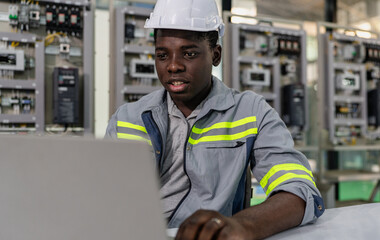 Professional computer engineer wear safety helmet sitting at desk working on programming...