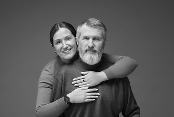 Dad with his grown-up daughter on grey background. Black-and-white toning