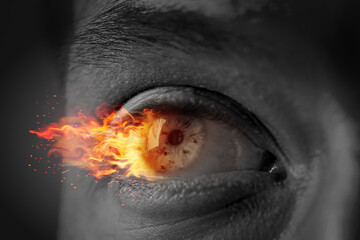 Man with fire burning in his eye, closeup. Black and white effect