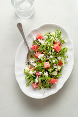 A light appetizer or an elegant side dish. Salad made with arugula, feta, pieces of watermelon and cucumber. Delicate flavor.